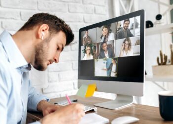 An employee sitting at his computer participating in an online training session