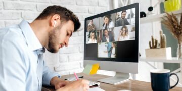 An employee sitting at his computer participating in an online training session