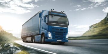 A haulage truck dramatically driving down a long stretch of road, delivering B2B goods