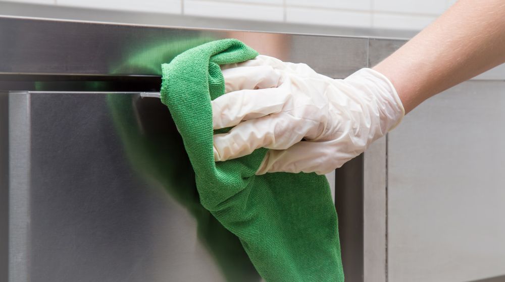 A cleaner cleaning a commercial kitchen in an office