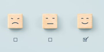 A series of symbols depicting standard customer service feedback icons with the positive smiley face ticked