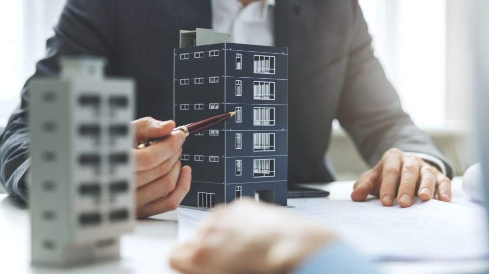 Man showing a commercial property as an example to his business partner with a pen.