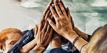 A team of people high fiving as a creative winning team.