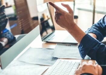 People in front of a desktop discussing about changes on their website business.