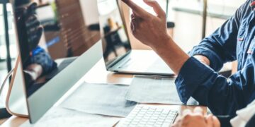 People in front of a desktop discussing about changes on their website business.