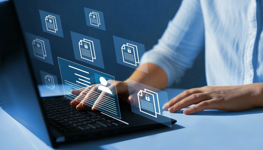 Company employee using a laptop to manage file system responsible for knowledge management