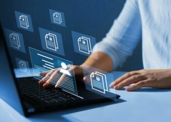 Company employee using a laptop to manage file system responsible for knowledge management