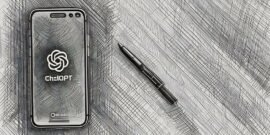 ChatGPT on a phone next to a low-tech pen