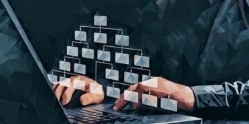 An organisational chart popping up over a person at a computer working on HR tasks