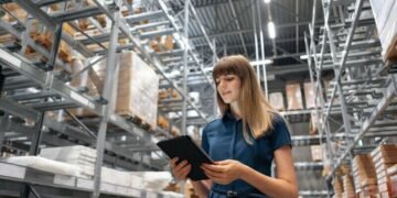 A warehouse manager walking through the warehouse looking at different products