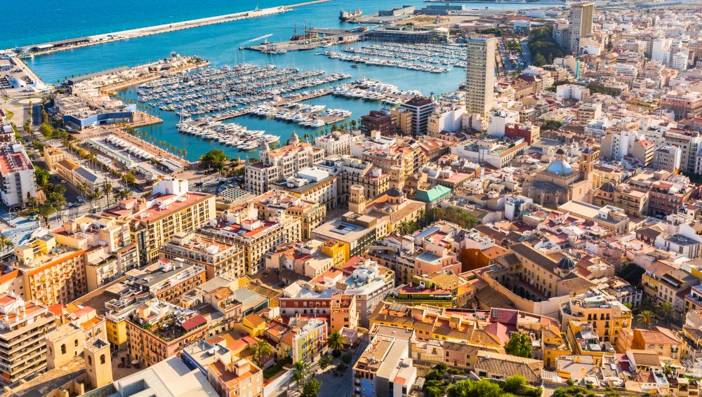 Alicante city panoramic aerial view with seaside, harbour and houses. Spanish city with beautiful beach. Travel and holidays concepts with a popular European summer destination.