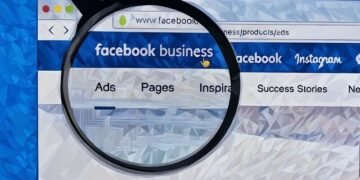 Magnifying glass over the logo of Facebook in a browser