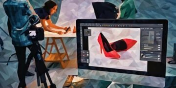 A photo editing suite open on a computer whilst a product photo shoot occurs in the background