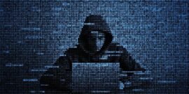 A hacker in code form working at a laptop to create ransomware