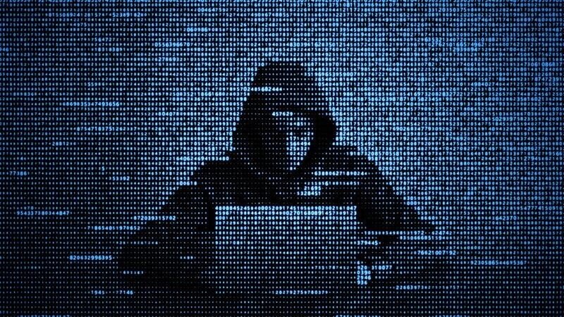 A hacker in code form working at a laptop to create ransomware