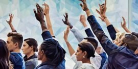 A group of employees in a workshop raising their hands to bid on a prize