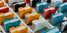 A series of physical filing folders lined up in different colours, being a representation of digital file systems and how they work