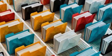 A series of physical filing folders lined up in different colours, being a representation of digital file systems and how they work
