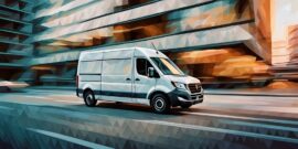 A commercial white van running through the city streets in blurred motion